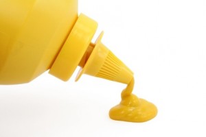 a bottle of yellow mustard with white background