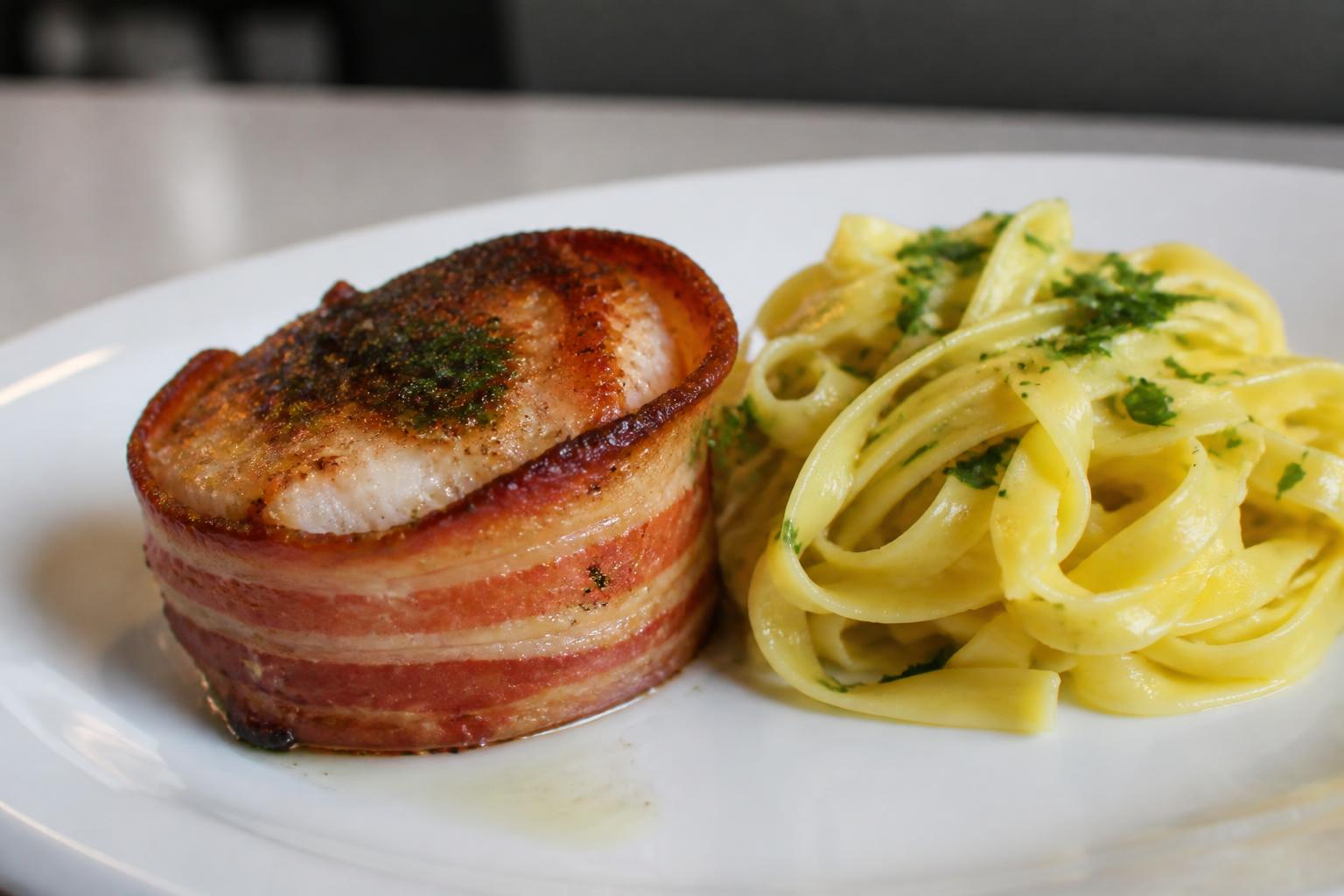 découvrez notre recette savoureuse de tournedos de lotte enveloppés de lard, accompagnés de tagliatelles fraîches pour un repas gourmand et élégant.